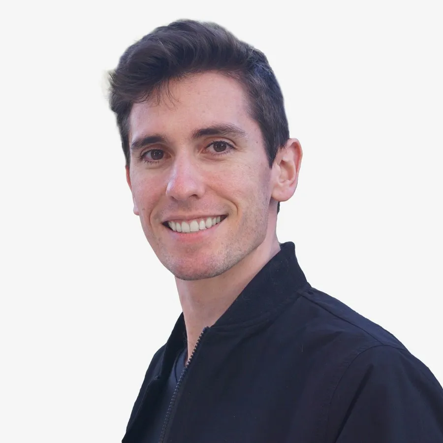 Jake Hartigan, smiling, photographed against a light grey background.