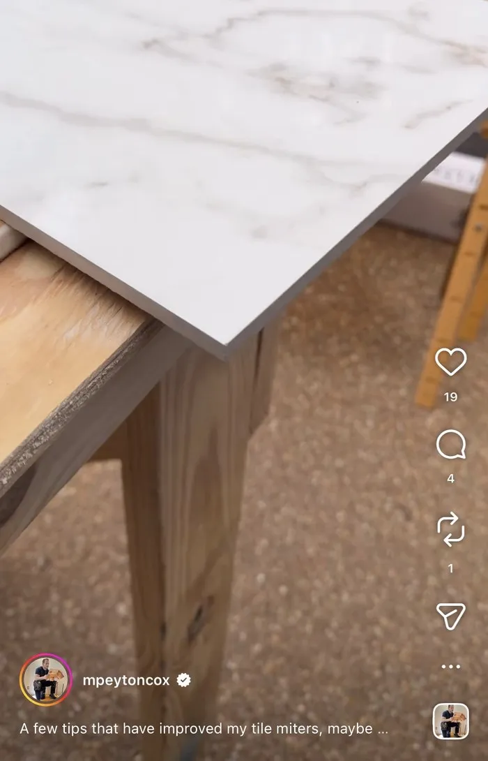 A mitred marble countertop edge meeting a raw timber base, shot on site.